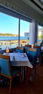 タラマンカにあるホテル アルゴス イビサのテーブルと椅子、大きな窓のあるレストラン