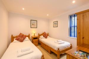 a bedroom with two beds and a table at Beachcombers Apartments in Newquay