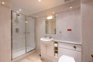 a bathroom with a sink and a shower at Beachcombers Apartments in Newquay