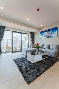 uma sala de estar com um sofá e uma mesa em HighSea GoldCoast Superview Apartment em Nha Trang