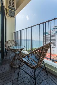 d'un balcon avec deux chaises et une table en verre. dans l'établissement HighSea GoldCoast Superview Apartment, à Nha Trang
