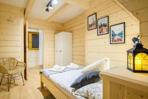 een slaapkamer met een bed in een kamer met houten wanden bij Apartament Kierunek Tatry in Bukowina Tatrzańska