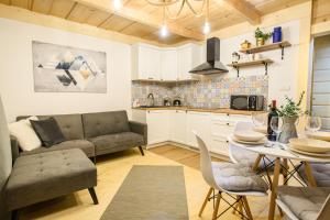 een keuken en een woonkamer met een bank en een tafel bij Apartament Kierunek Tatry in Bukowina Tatrzańska