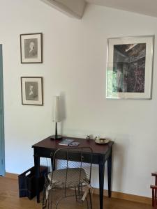 a desk with a lamp and a chair in a room at Face au Palais in Avignon