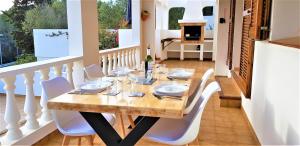 a dining room with a wooden table and white chairs at Casa Toro Vista in Son Parc