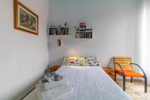 - une petite chambre avec un lit et une chaise dans l'établissement Casa Caterina, à Pozzallo