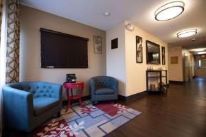 una sala de espera con 2 sillas azules y una mesa roja en Sonesta Simply Suites Chicago Naperville, en Warrenville