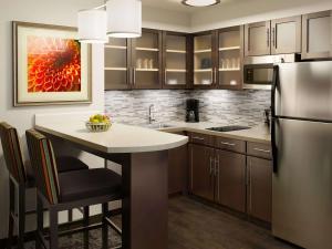 a kitchen with a kitchen island with a refrigerator at Sonesta ES Suites Toronto Markham in Markham