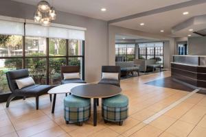 a lobby with a table and chairs and windows at Sonesta ES Suites New Orleans Convention Center in New Orleans