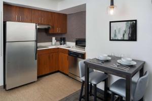 a kitchen with a stainless steel refrigerator and a table at Sonesta ES Suites New Orleans Convention Center in New Orleans