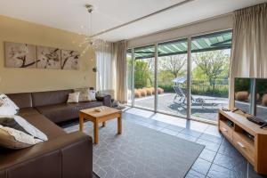 ein Wohnzimmer mit Sofa und Tisch in der Unterkunft Bandol 186 - Kustpark Village Scaldia in Hoofdplaat