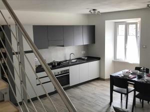 uma cozinha com um lavatório e uma mesa com uma sala de jantar em Appartamento "Via Ferrata" - aut SUAP 16836 em Mori