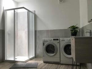 a laundry room with a washing machine and a mirror at Appartamento "Via Ferrata" in Mori