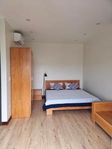 ハロンにあるLittle Cloudy on the hilltopのベッドルーム1室(ベッド1台付)、木製キャビネットが備わります。