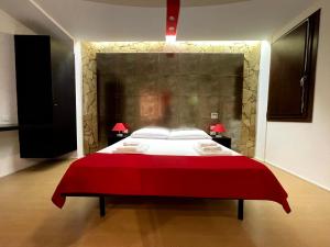 a large bed in a room with a red wall at Le Torri in Cagliari