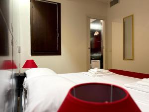 a hotel room with two beds and a mirror at Le Torri in Cagliari