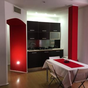una cucina con tavolo e parete rossa di Le Torri a Cagliari Altre 37 foto