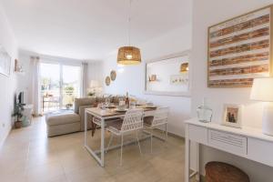 a dining room and living room with a table and chairs at Golden Beach in Jávea