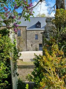 einen Eingang zu einem Steinhaus mit einem Dach in der Unterkunft La Seigneurie des Ondes in Saint-Benoît-des-Ondes