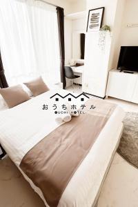 - une chambre avec un lit dans une chambre avec un bureau dans l'établissement OUCHI HOTEL Fujimi, à Hiroshima