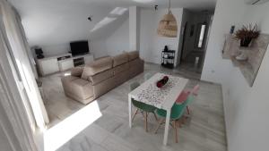 a living room with a couch and a table and chairs at Apartamentos La Casa de Bebita in Fuengirola