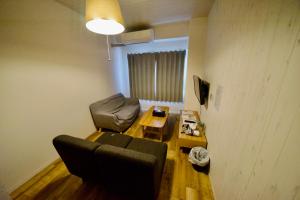 a living room with a couch and a table at Guest House Re-worth Yabacho1 402 in Nagoya