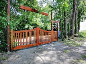uma cerca de madeira com um portão em frente às árvores em Ośredek Wypoczynkowy MEDUSA em Rusinowo