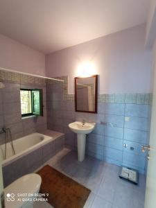 y baño con bañera, lavamanos y bañera. en Villa Sklithro in the heart of the forest with magnificent view of the sea just 10 minutes from it, en AgiaKampos