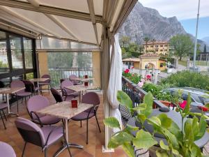 a patio with tables and chairs and a view of mountains at Hotel Villa Grazia in Limone sul Garda
