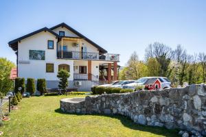 a house with a stone wall in front of it at Deluxe Apartments Franjkovic in Seliste Dreznicko