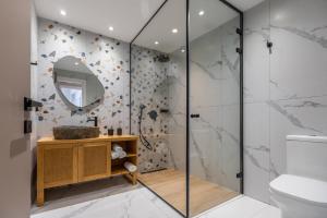 a bathroom with a shower with a sink and a mirror at Moncasa Al centro in Lixouri +37 photos