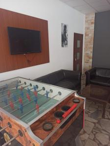 a living room with a large wooden table with a pool table at Motel Šofér in Volkovce