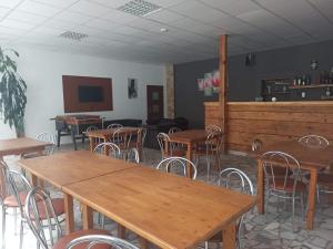 comedor con mesas y sillas y TV en Motel Šofér en Volkovce