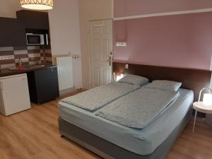 a bedroom with a large bed and a kitchen at Downtown Apartments Budapest in Budapest