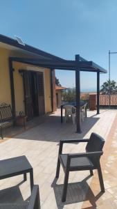 a patio with tables and chairs and a pergola at La Terra Patrizia in Nicolosi