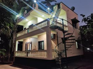 a house with a spiral staircase in front of it at Rama Niwas Beach Home Stay in Pawas