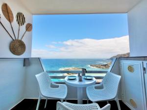 a balcony with a table and chairs and the ocean at Coastal Vibe in Tacoronte