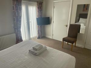 a bedroom with a bed with two towels on it at The Moorings Hotel in Edmondsley