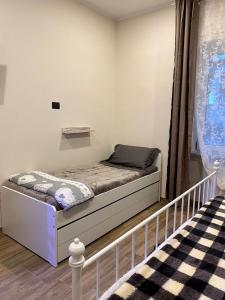 una piccola camera con letto e finestra di B&B Staziona e Dormi a Camigliatello Silano
