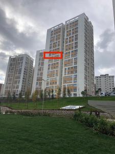 a large building with a red sign in a park at Comfortable and spacious condo in a new site. in Istanbul