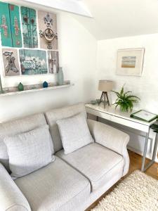 a living room with a couch and a table at Idyllic Cornish Cottage, Superking bed, private garden dogs welcome in Truro