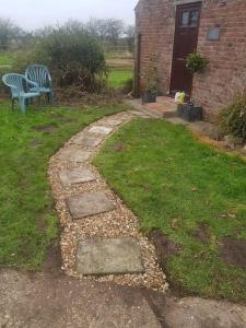 a garden with a bench and a stone path at Amazingly quiet and peaceful studio getaway. in Woodhall Spa