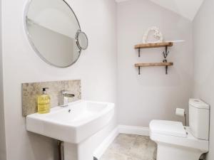 a white bathroom with a sink and a mirror at Millgate House in Conwy +17 photos
