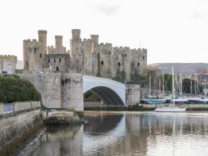 a castle with a bridge over a body of water at Millgate House in Conwy
