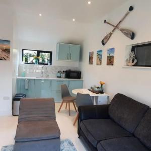 uma sala de estar com um sofá e uma cozinha em Sycamore Lodge Kent With EV Zappi type 2 em Sellindge