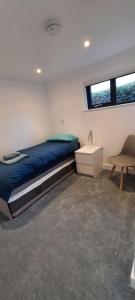 a bedroom with a bed and a desk and a chair at Sycamore Lodge Kent With EV Zappi type 2 in Sellindge