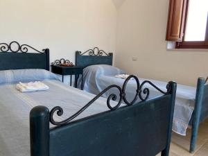 a bedroom with two beds with blue sheets at I Trulli del Mulino in Locorotondo