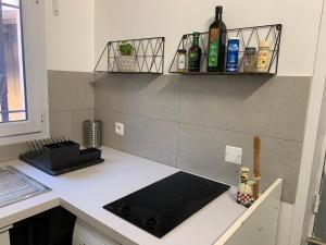 a kitchen with a counter with bottles of wine at Studio Oustaou à Château Gombert in Marseille +4 photos