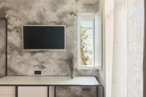 a living room with a tv on a wall at Elayio Old Town in Tinos