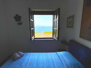 a bedroom with a window with a view of the ocean at Appartamento con vista mare a Terramala in Terra Mala